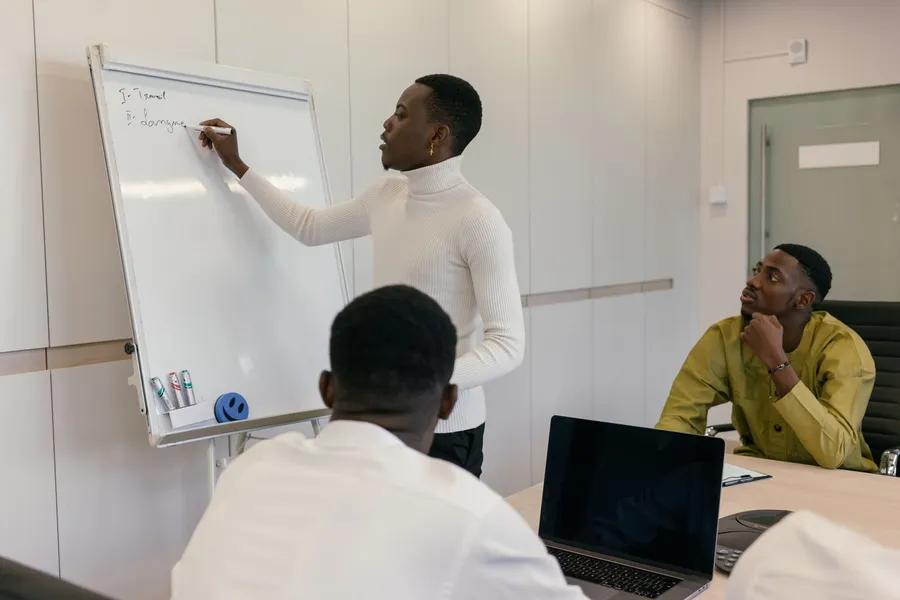 A team writing up a problem on a whiteboard in a meeting room